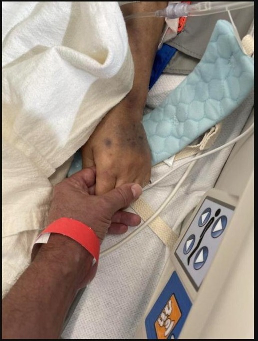 Loved ones holding hands, supporting a patient through treatment