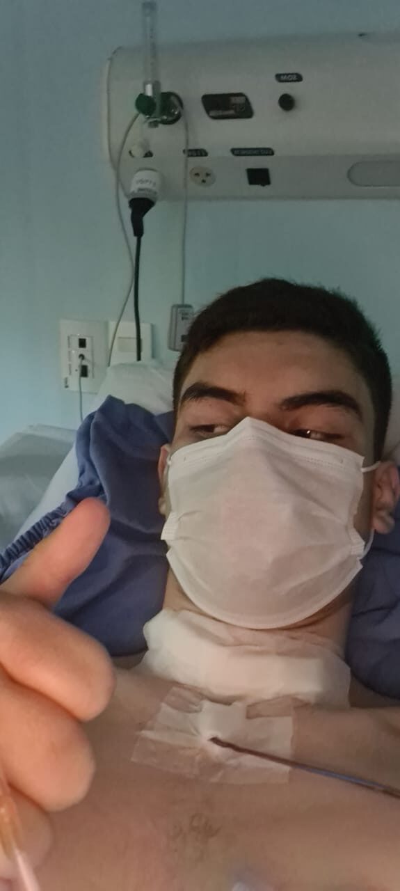 A young patient giving a thumbs-up during treatment